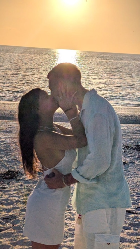 Couple embracing at golden sunset on a Marco Island beach during a Sand Dollar proposal charter