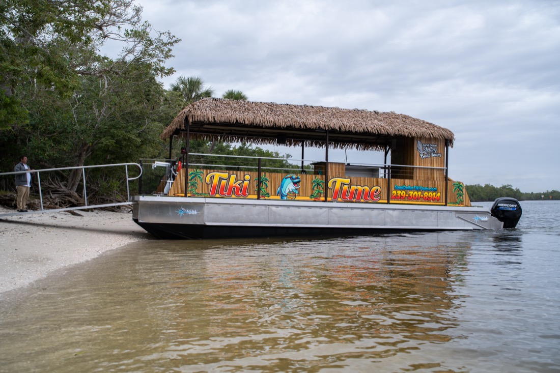 The Sand Dollar Boat Tours thatched-roof tiki boat beached on a Ten Thousand Islands sandbar