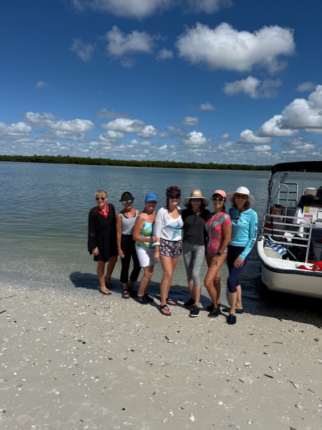 Group of friends relaxing on a Ten Thousand Islands sandbar beside a Sand Dollar pontoon boat, Marco Island