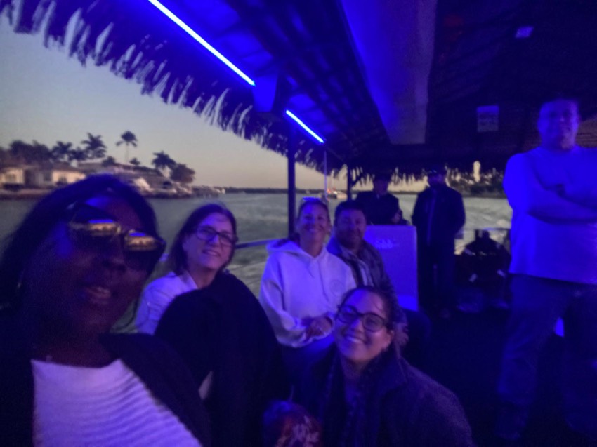 Guests enjoying a Sand Dollar tiki boat night cruise lit with blue LED lights near Marco Island, Florida