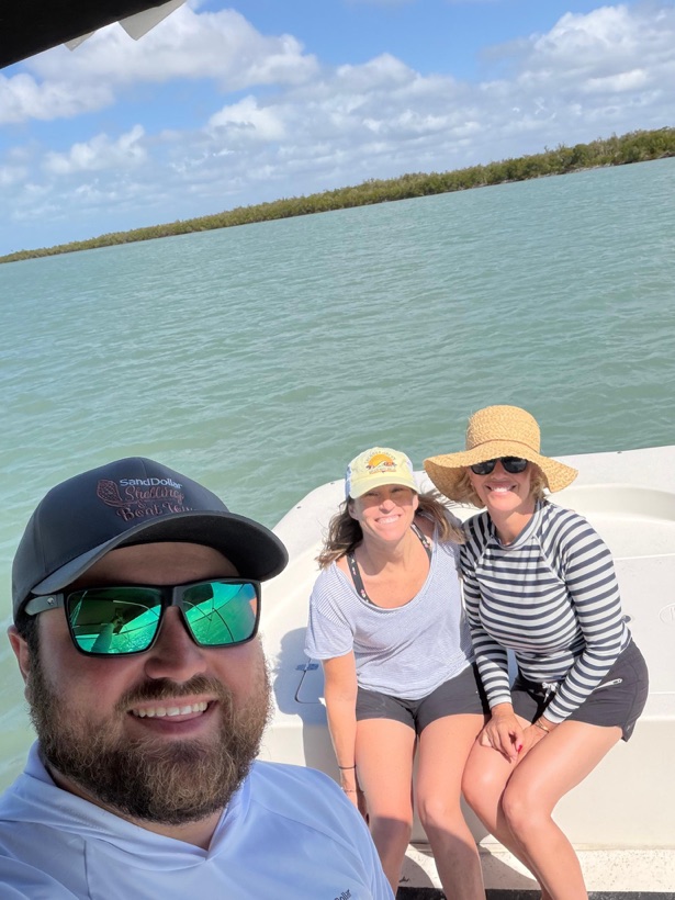 A Sand Dollar captain taking a selfie with two guests over turquoise water near Marco Island, Florida
