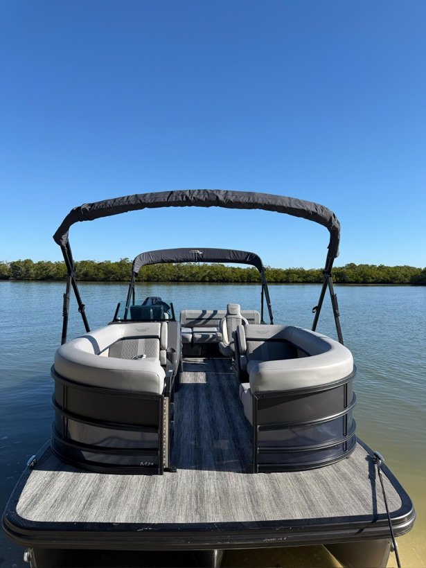 A clean, empty luxury pontoon boat deck waiting on a Marco Island waterway, Florida