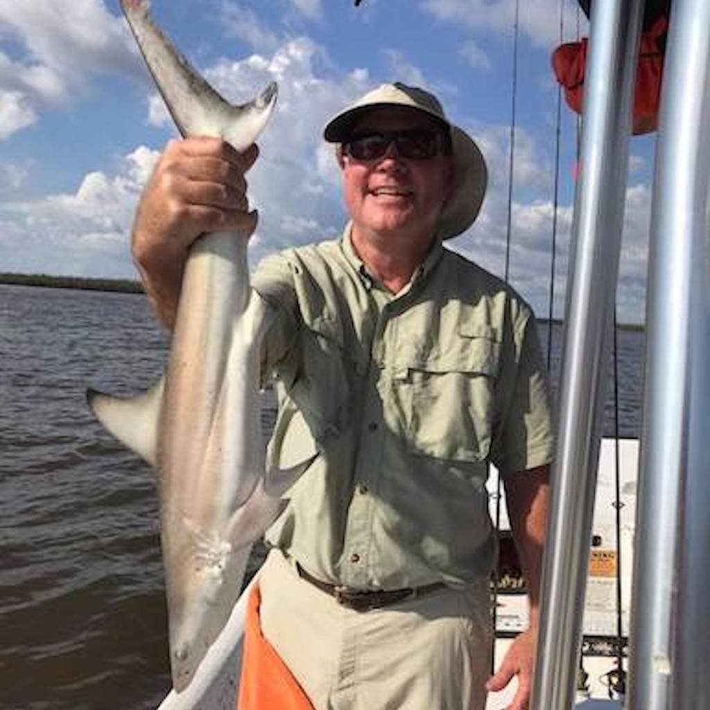 A silver disc-shaped pompano caught on light tackle over sandy bottom near Naples, Florida