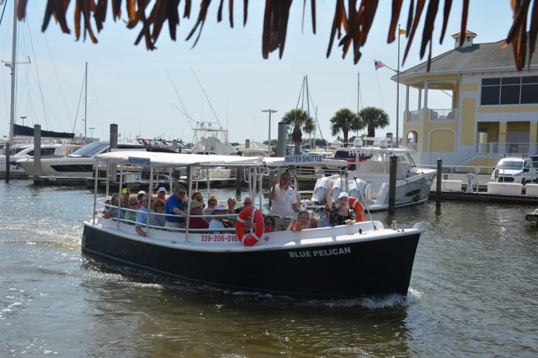 The water shuttle cruising past palms and the marina on Naples Bay, Florida