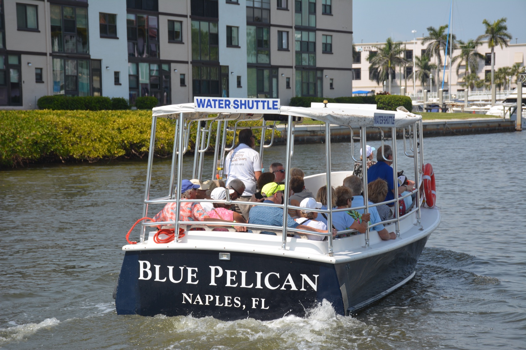The Blue Pelican Naples Bay Water Shuttle full of happy guests cruising Naples Bay, Florida