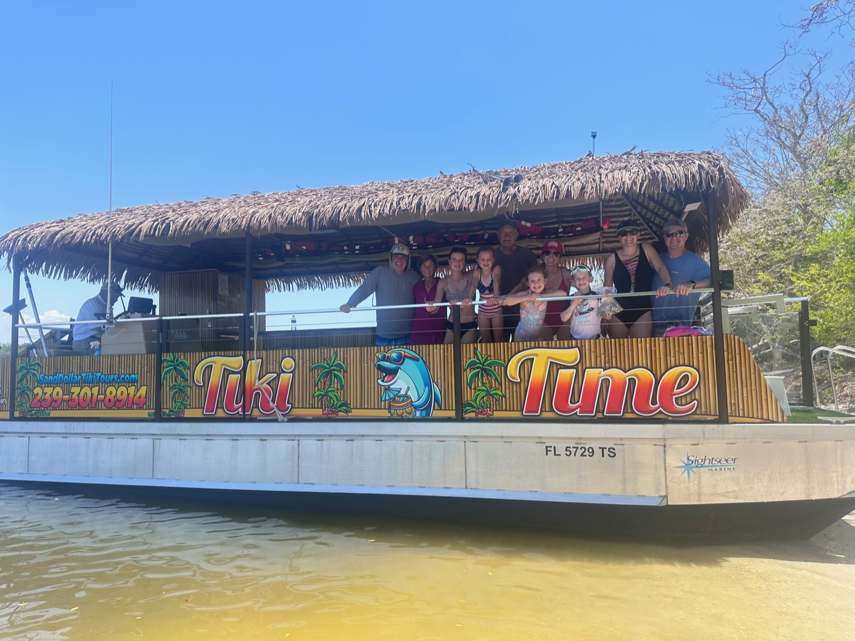 A multigenerational family aboard the Sand Dollar Tiki Time boat with its thatched roof near Marco Island, Florida